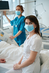 Obraz premium Female medics near patient's bed in hospital