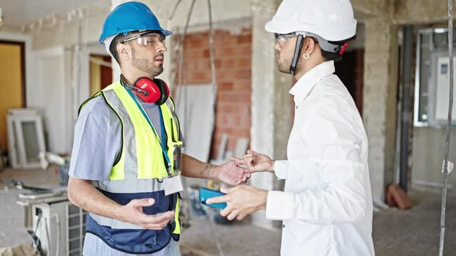 Two men builder and architect arguing at construction site