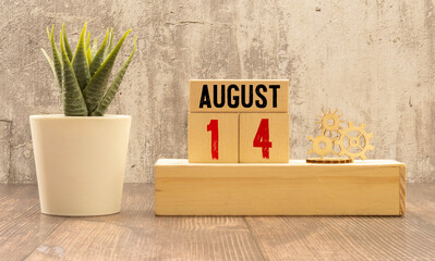 August 14 calendar date text on wooden blocks with blurred background park. Calendar concept.