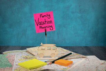 Family vacation planning handwritten on a posted note with old road maps