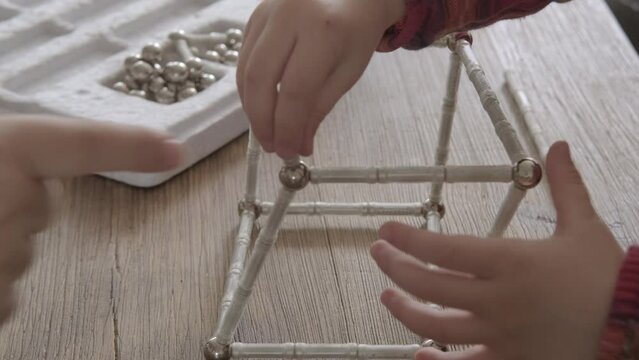 mother and child together assemble structures from magnetic constructor parts, development abstract, spatial thinking, child's imagination, engineering, fine motor skills