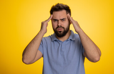 Fototapeta na wymiar Sick ill caucasian bearded young man rubbing temples to cure headache problem, suffering from tension, migaine, stress, grimacing in pain, high blood pressure isolated alone on yellow wall background
