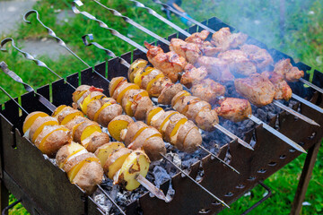 In these portable metal BBQ braziers, kebabs skewers and potatoes with bacon are grilled to...