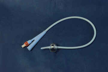 Foley catheter in a dark blue background with a insuflated balloon. - obrazy, fototapety, plakaty