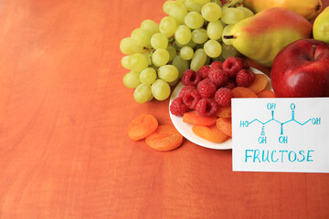 Card with word Fructose, delicious ripe fruits, raspberries and dried apricots on wooden table, space for text