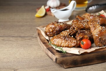 Tasty chicken glazed in soy sauce served on wooden table, closeup. Space for text