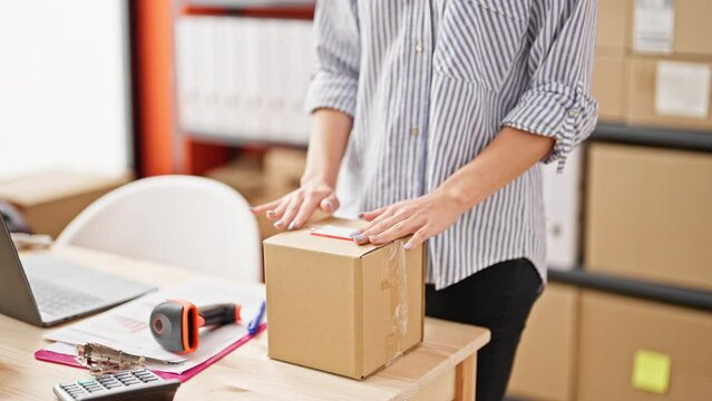 Young caucasian woman ecommerce business worker scanning package sticking label at office