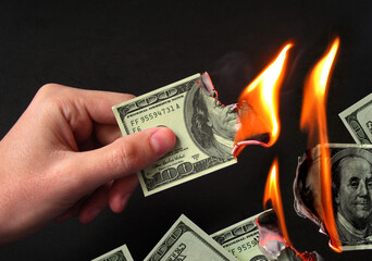 Hand burning dollar bills