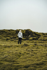 Naklejka na ściany i meble Woman standing in the mossy lava fields in Iceland