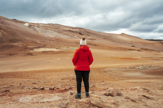 Woman looking out at the geothermal fields of Námafjall near Lake Mývatn in Iceland