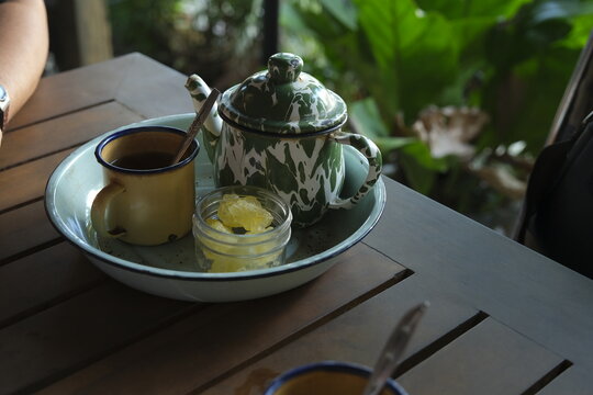Poci Tea, Teh Poci or tea in enmamel pot oj the table with ature background. Javanese traditional drink