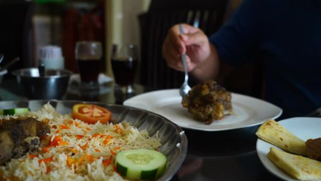 Close-up hands picking nasi mandi to eat showcases the intimate act of selecting and enjoying this flavorful dish. Nasi mandi is a traditional Middle Eastern rice dish that is known for its fragrant