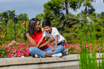 Fototapeta premium Mother and son having fun together while enjoying a day in the park.