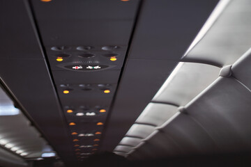 no smoking sign light up on ceiling of airplane cabin above passenger seat that mean cigarette is...
