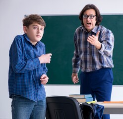 Fototapeta na wymiar Funny male teacher and boy in the classroom