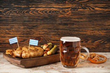 Mug of cold beer and different snacks on table. Oktoberfest celebration