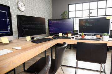 Programmer's workplaces with computer monitors in office