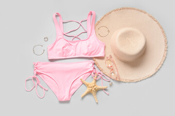 Composition with stylish swimsuit, hat, sunglasses, accessories and starfish on light background