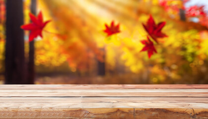 Naklejka na ściany i meble Wooden table and blurred Autumn background. Autumn concept with red-yellow leaves background.