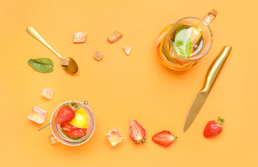 Frame made of ingredients for preparing strawberry lemonade and glass of drink on orange background