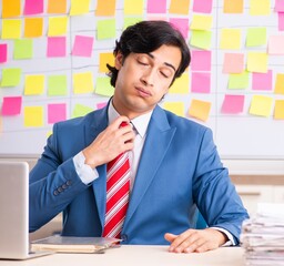Young handsome employee with many conflicting priorities