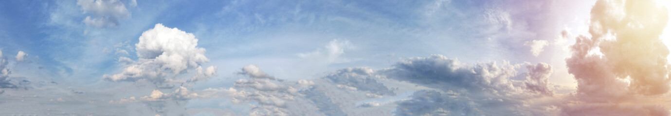 Panorama landscape a serene sky adorned with fluffy orange clouds, while the warm rays of the sun light on the right side painted a golden glow, casting a breathtaking display of light and shadow over