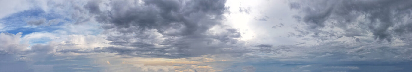 Obraz premium Panorama landscape of white and blue clouds, as the warm glow of the orange light cast a vibrant and magical aura, infusing the scene with a sense of wonder and enchantment.