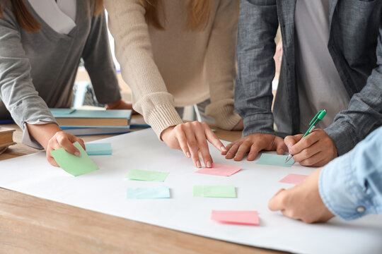 Group of teenage students performing task at table in classroom, closeup