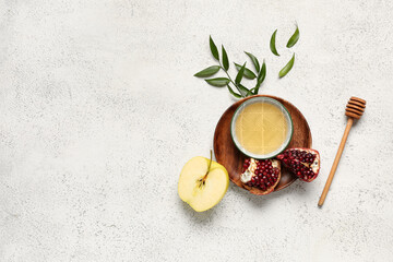 Plate with bowl of honey, pomegranate and apple for Rosh Hashanah celebration (Jewish New Year) on white background