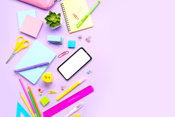 Different stationery with mobile phone on lilac background