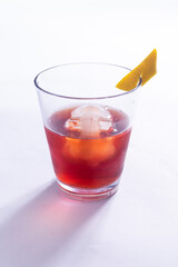 Drink vermelho com pedra de gelo e raspa de limão