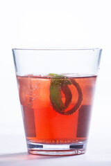 Drink vermelho, Negroni com limão, servido com gelo em um fundo branco