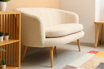 Modern living room interior with cozy white sofa, shelving unit and plants