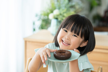 チョコレートドーナツを食べる子供