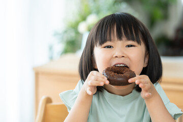 チョコレートドーナツを食べる子供