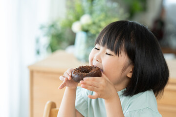 チョコレートドーナツを食べる子供