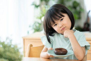 チョコレートドーナツを食べる子供