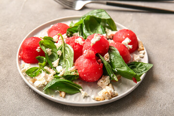 Plate of tasty watermelon salad on grey background