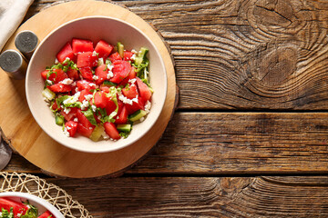 Bowl of tasty watermelon salad on wooden background