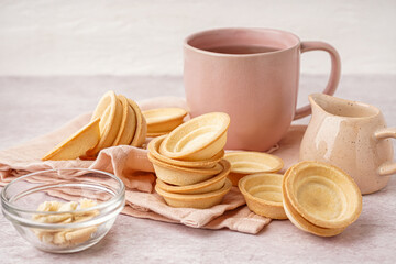 Homemade tartlets and cup of hot tea on light background