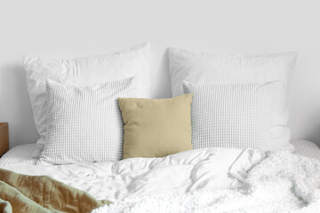 Soft pillows and white blanket on bed, closeup