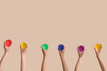 Female hands with colorful baking forms on beige background
