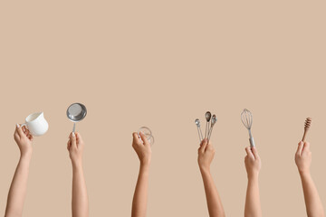 Female hands with baking utensils on beige background