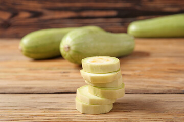 Slices of fresh green zucchini on wooden background