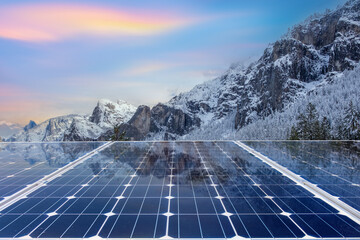 Solar panels with mountain landscape at sunset. Green energy concept.