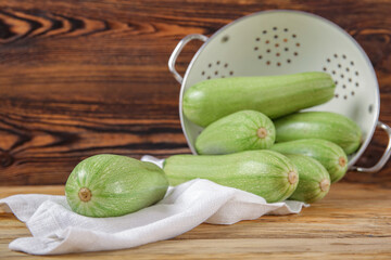 Fresh green zucchini on wooden background