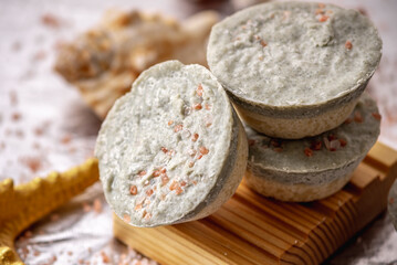 Natural soap with sea salt on a wooden soap dish, shells and a starfish. Organic summer soap, immersing in the marine atmosphere