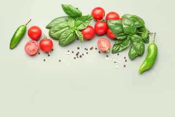 Fresh basil, cherry tomatoes and peppercorn on green background