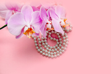 Pearl necklace and Purple orchid on pink background
