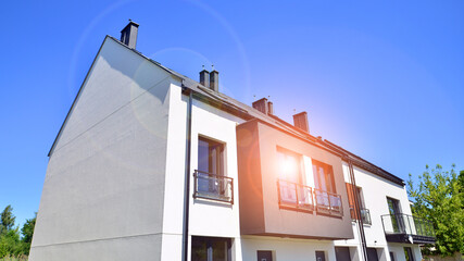 New single family houses in a new development area. Residential homes with modern facade. Terraced family homes in newly developed housing estate. The real estate market in the suburbs.